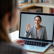 Tutor waving to student on laptop, remote online language lesson